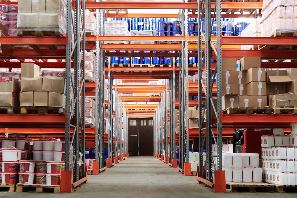 Warehouse aisle with racking stacked full of palletised beverage and packaging stock